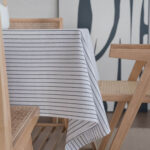 Thick striped linen blend tablecloth laid on wooden dining table