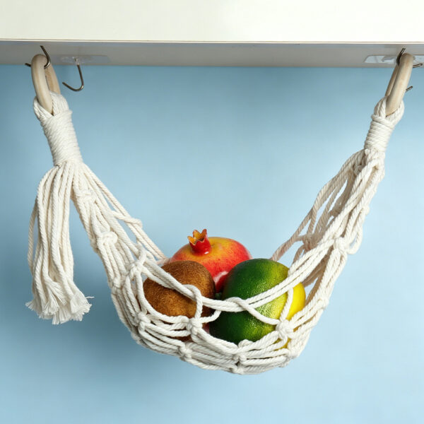 Cotton macrame holder fruit hammock hanging on blue tiled kitchen wall