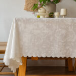 White floral lace jacquard tablecloth on wooden table for tea party