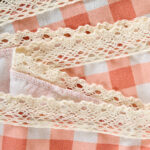 Close‑up view of gingham lace trim on pink floral tablecloth
